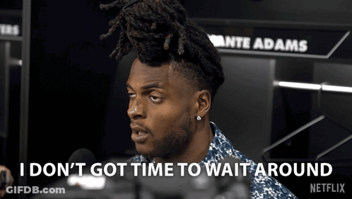 A Man Talking Into A Microphone With The Words " I Don 'T Got Time To Wait Around " Behind Him GIF