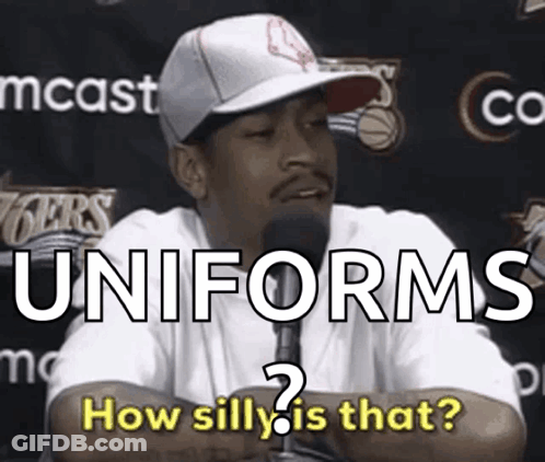 A Man Talking Into A Microphone With The Words Uniforms How Silly Is That Behind Him GIF