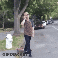 A Man Talking On A Cell Phone While Walking Down A Street GIF