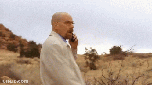 A Man Talking On A Cell Phone While Walking In The Desert GIF