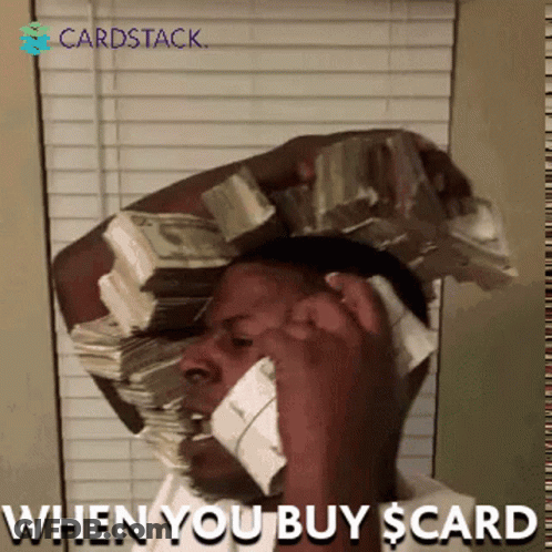 A Man Talking On A Cell Phone With A Stack Of Money On His Head GIF