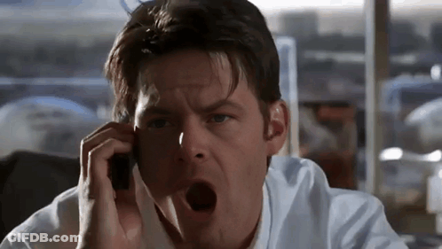 A Man Talking On A Cell Phone With His Mouth Wide Open GIF