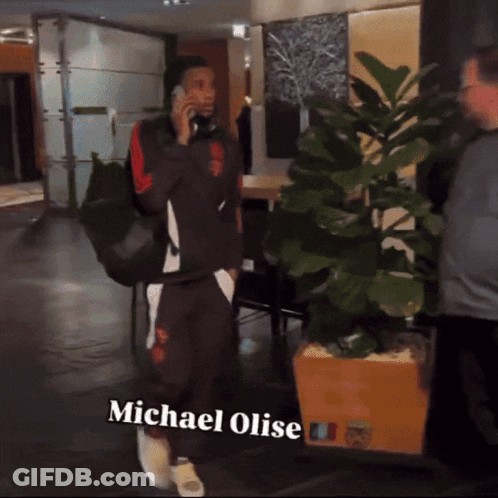 A Man Talking On A Cell Phone With The Name Michael Olise On The Bottom Right GIF