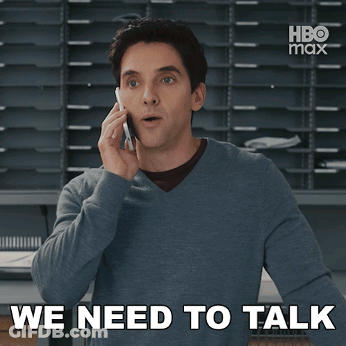 A Man Talking On A Cell Phone With The Words We Need To Talk Behind Him GIF