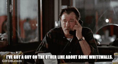 A Man Talking On A Phone With The Words " I 'Ve Got A Guy On The Other Line About Some Whitewalls " Below Him GIF