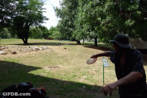 A Man Throwing A Frisbee In A Park With A Sign That Says ' A Few Steps ' On It GIF