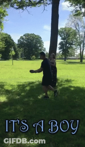 A Man Throws A Frisbee In A Park With The Words It 'S A Boy GIF