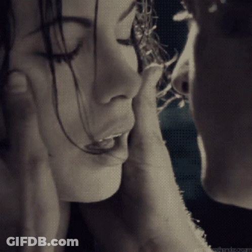 A Man Touches A Woman 'S Face With His Hand GIF