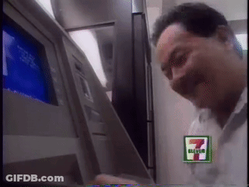 A Man Using An Atm Machine With A 7 Eleven Logo GIF