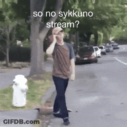 A Man Walking Down A Street Talking On A Cell Phone With The Words So No Sykkuno Stream Below Him GIF