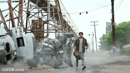 A Man Walking Down A Street With A Robot In The Background And A Sign That Says ' A.m. ' On It GIF