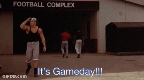 A Man Walking In Front Of A Sign That Says " Football Complex " GIF