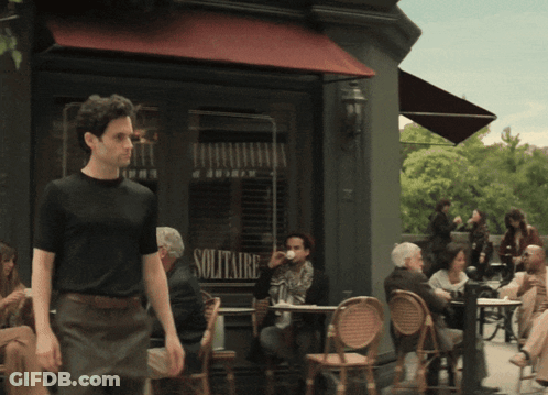 A Man Walking In Front Of A Solitaire Store GIF