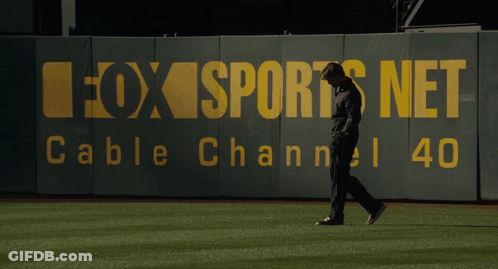 A Man Walking On A Baseball Field In Front Of A Fox Sports Net Cable Channel 40 Sign GIF