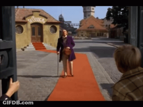 A Man Walking On A Red Carpet In Front Of A Building With The Word Wonka On It GIF