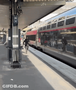 A Man Walking Towards A Train That Has The Number 41 On It GIF