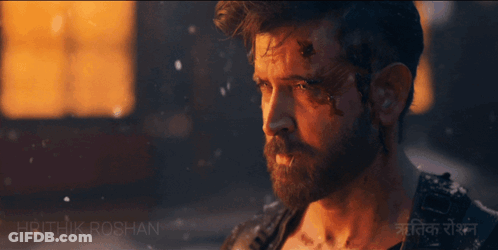 A Man Walking With A Wolf In Front Of A Building With The Name Hrithik Roshan On The Bottom GIF