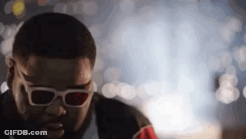 A Man Wearing 3D Glasses Is Looking Down At Something . GIF