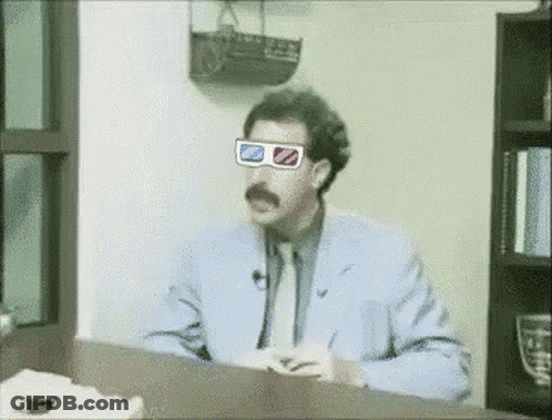 A Man Wearing 3D Glasses Sits At A Table GIF
