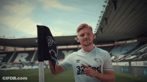 A Man Wearing A 32 Ed Jersey Points To A Flag GIF