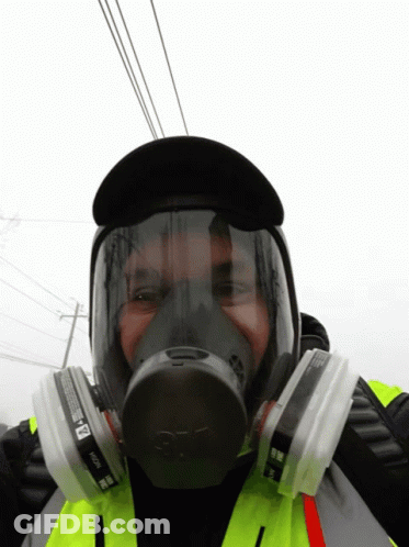 A Man Wearing A 3M Gas Mask With Two Filters GIF