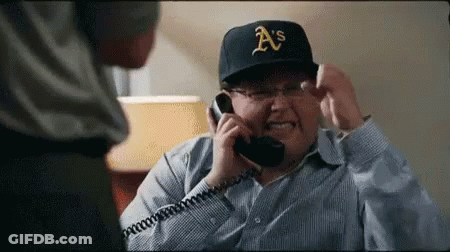 A Man Wearing A A 'S Hat Is Talking On A Phone GIF