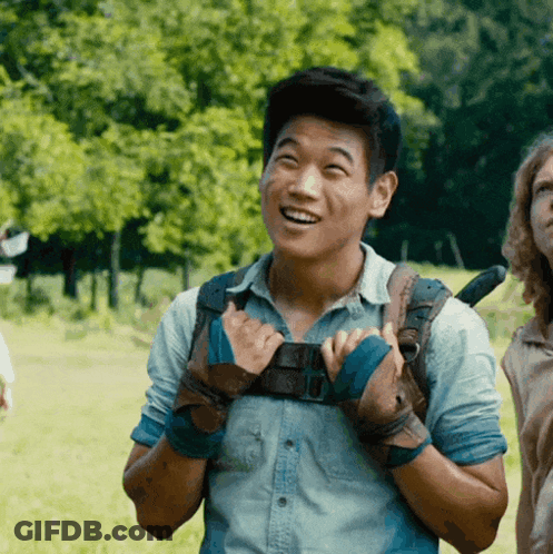 A Man Wearing A Backpack And Gloves Is Smiling GIF