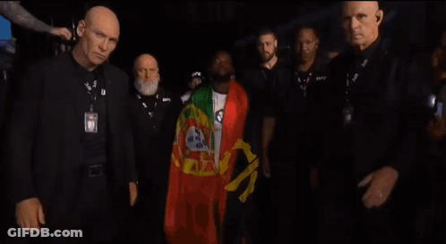 A Man Wearing A Badge That Says Ufc Walks Through A Crowd GIF