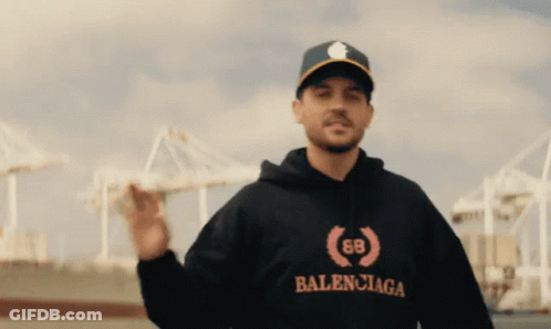 A Man Wearing A Balenciaga Hoodie And A Baseball Cap GIF