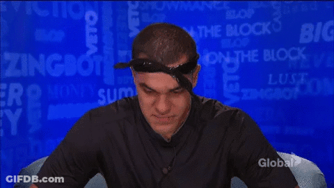 A Man Wearing A Bandana And A Black Shirt Is Sitting In Front Of A Blue Background With The Word Block On It . GIF