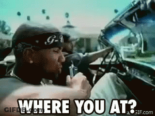 A Man Wearing A Bandana Is Driving A Car And Asking Where You At GIF