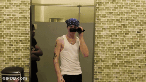 A Man Wearing A Bandana Taking A Picture Of Himself In A Bathroom Mirror GIF