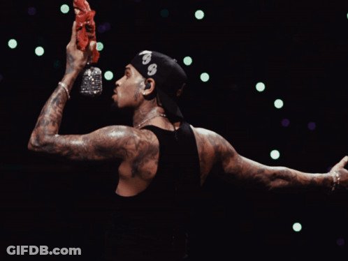 A Man Wearing A Bandana With The Number 99 On It Holds A Bottle Of Water In His Hand GIF