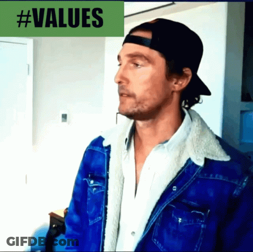 A Man Wearing A Baseball Cap And A Denim Jacket Stands In Front Of A #Values Sign GIF