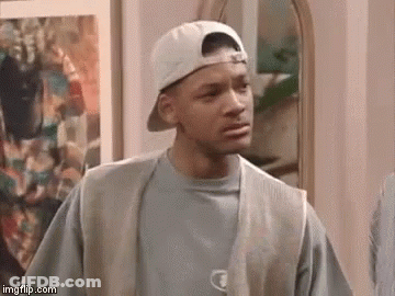 A Man Wearing A Baseball Cap And Vest Is Standing In Front Of A Mirror . GIF