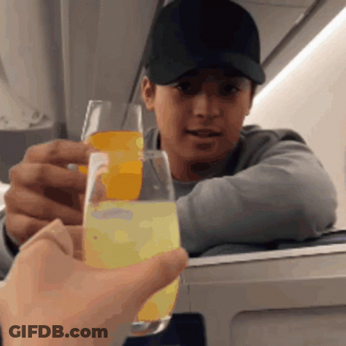 Man In Baseball Cap Holding Glass Of Orange Juice GIF