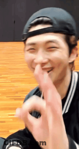A Man Wearing A Baseball Cap Is Making A Heart With His Fingers GIF