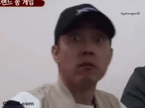 A Man Wearing A Baseball Cap Is Making A Surprised Face . GIF