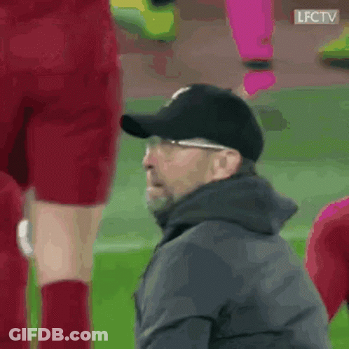 A Man Wearing A Baseball Cap Is Sitting On The Sidelines Of A Soccer Game . GIF