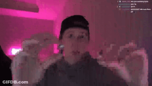 A Man Wearing A Baseball Cap Is Smiling In Front Of A Pink Background GIF