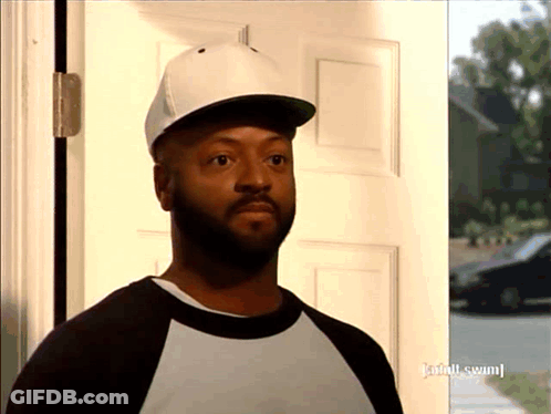 A Man Wearing A Baseball Cap Is Standing In Front Of A Door That Has Adult Swim Written On It GIF