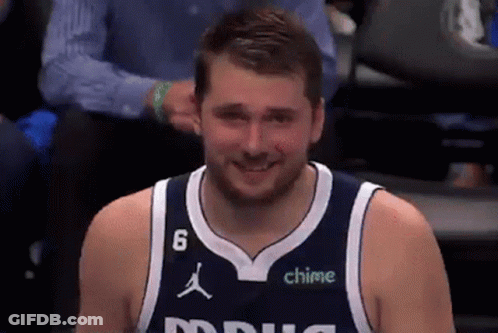 A Man Wearing A Basketball Jersey With The Number 6 On It Is Smiling . GIF