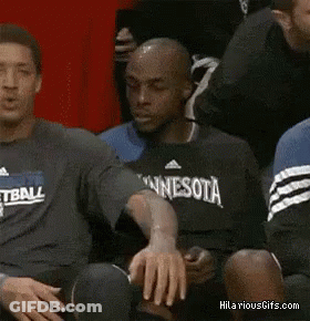 A Man Wearing A Basketball Shirt Is Sitting On The Bench GIF