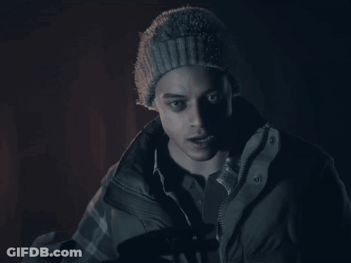 A Man Wearing A Beanie And A Jacket Is Giving The Peace Sign GIF