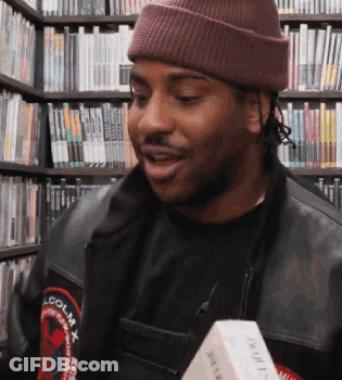 A Man Wearing A Beanie And A Jacket That Says Lcolmx GIF