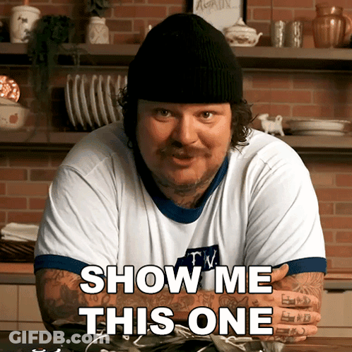 A Man Wearing A Beanie And A T-Shirt That Says Show Me This One GIF