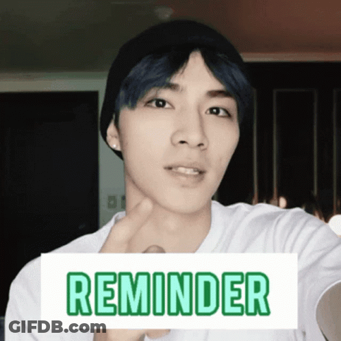 A Man Wearing A Beanie And A White Shirt Has A Sign That Says Reminder On It GIF