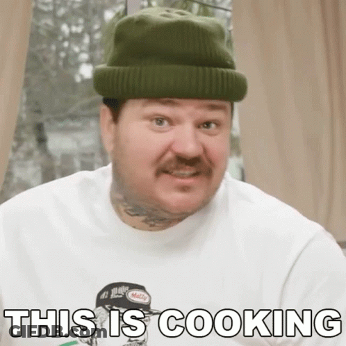 A Man Wearing A Beanie And A White Shirt Says This Is Cooking GIF