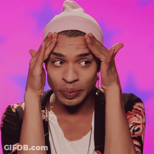 A Man Wearing A Beanie And Earring Holds His Hands To His Forehead GIF