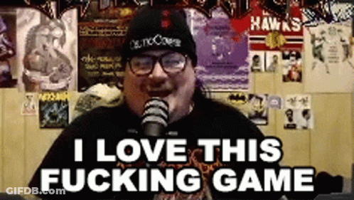 A Man Wearing A Beanie And Glasses Is Talking Into A Microphone And Says I Love This Fucking Game . GIF